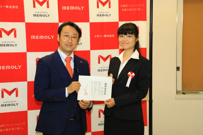 笑顔で証書を受け取るスーツを着た女性