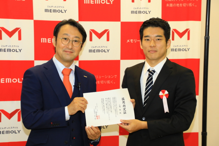 緊張の趣きで証書をもらうスーツを着た男性