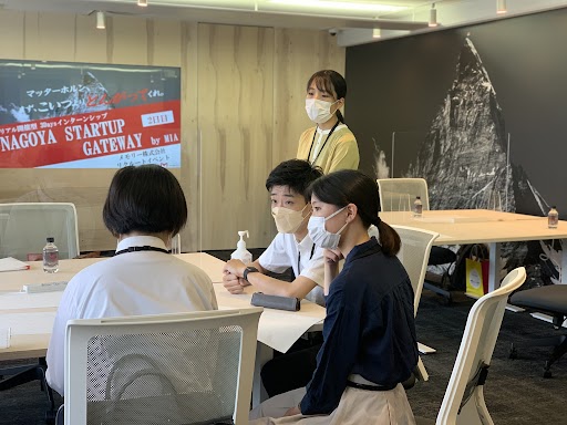 1名の学生の発言を真剣な眼差しで聞く2名の学生と1名の社員