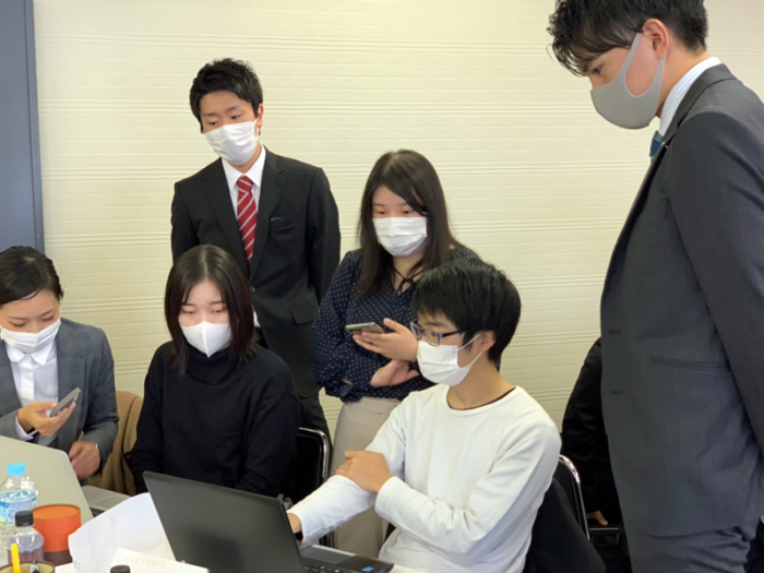 課題について相談しあう学生達
