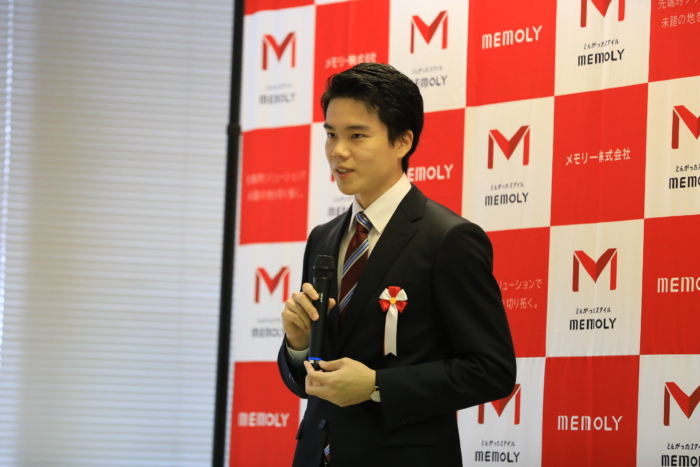 弾幕前で落ち着いた雰囲気でマイクを持つ男性内定者