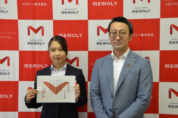 採用内定賞を掲げる内定者と隣に立つ社長