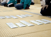 畳の上でかるたを並べ星座をしている大会の様子