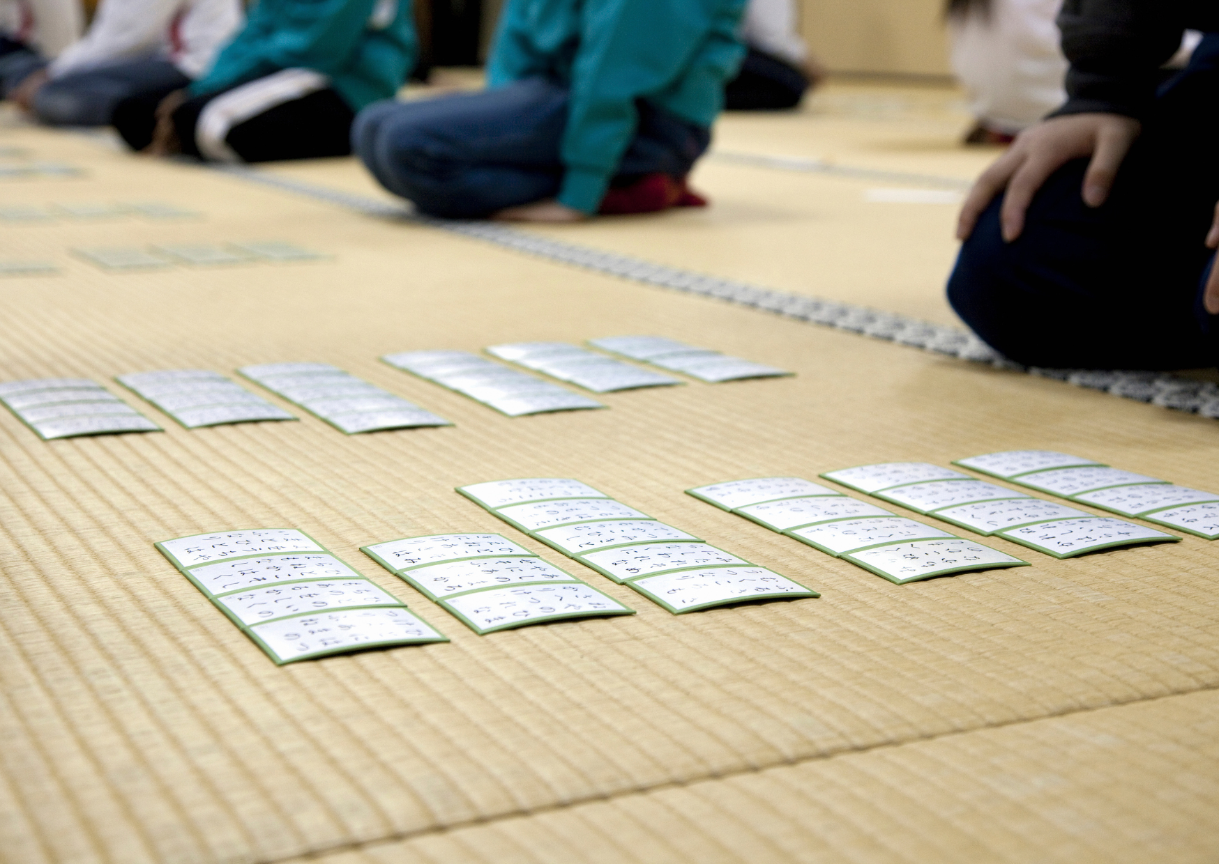 畳の上でかるたを並べ星座をしている大会の様子