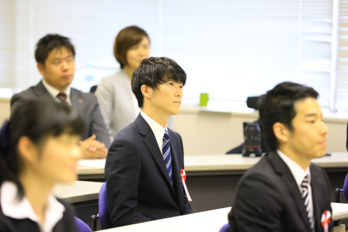 着座して真剣に話を聞く男性社員