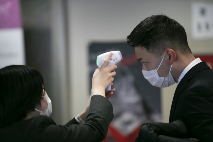 検温される長身の就活生と女性社員