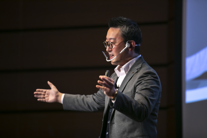 手を大きく広げ訴えるメガネの男性