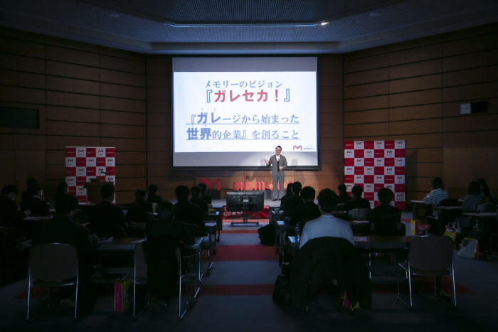 ステージで企業理念を大勢に伝える社長